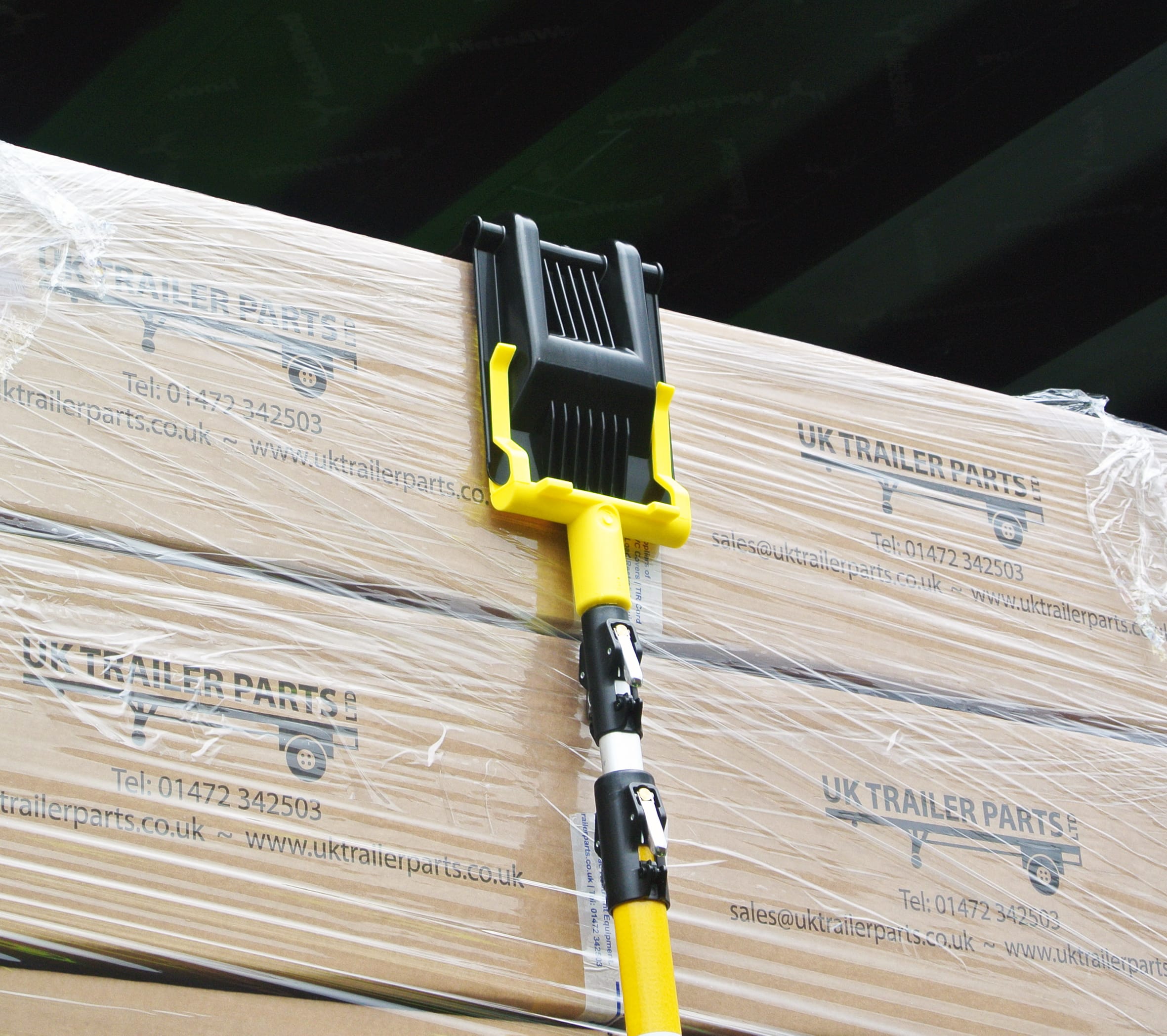 Corner protector attachment head placing a CP03 corner protector on top of boxes.